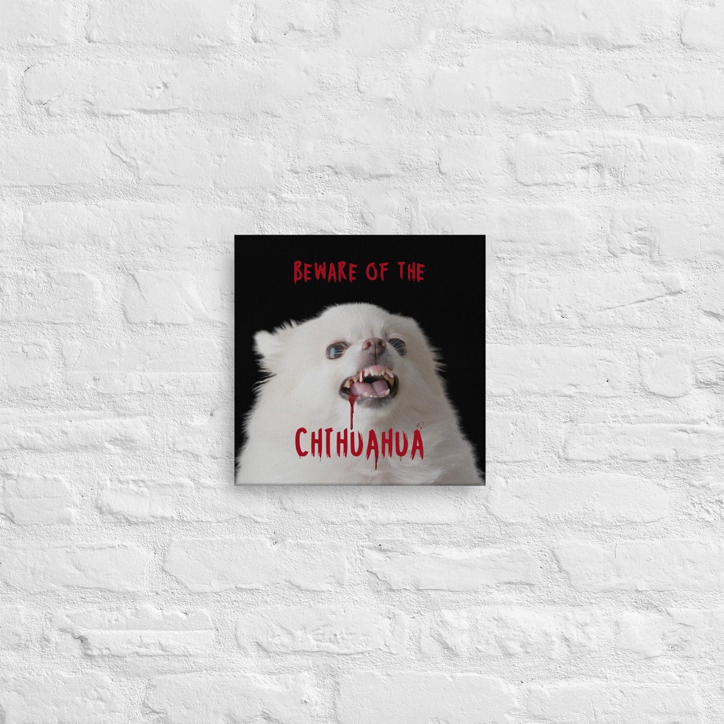BEWARE OF THE CHIHUAHUA - one of the famous Chimigos chihuahua memes. This is a vivid and fade resistant art print on a stretched canvas. An angelic fluffy white chihuahua with bloody fangs reminds us that looks can be deceiving. Beware of the chihuahua! A punky gift idea for someone whose house is guarded by a cute but vicious little chi. Perfect for the new chihuahua parent, as a housewarming gift, or maybe for Halloween!