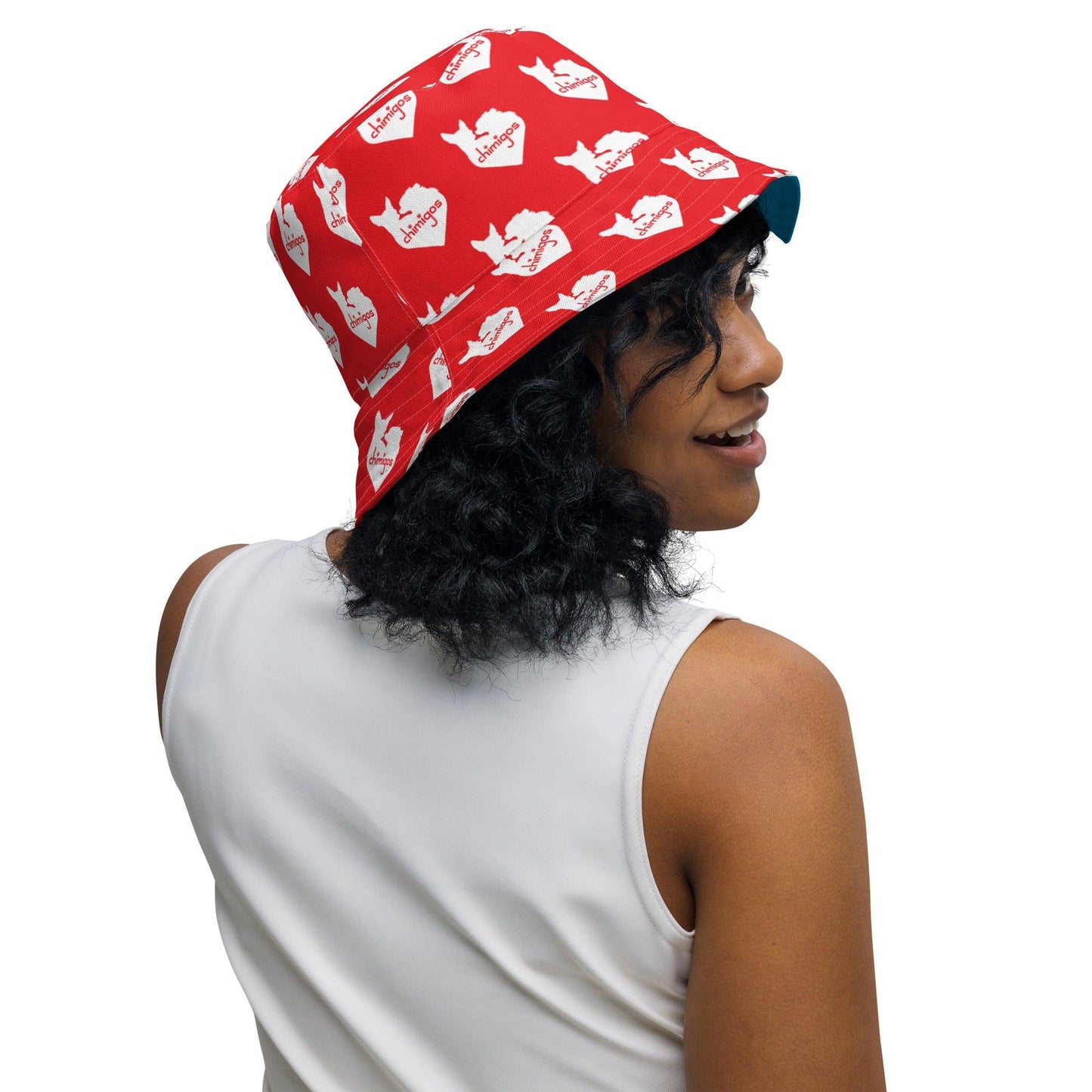 Chihuahua + Shark = Chark reversible bucket hat. Blue outer with black silhouette of a longhaired chihuahua with the face of a great white shark + "Chark" in red cursive font, and another shark-faced chihuahua silhouette running on the brim, below a dictionary entry of the noun "chark": a chihuahua with teeth like a shark. Red inner scattered with white cute love heart Chimigos logos. Unisex in two sizes. Design by Renate Kriegler, owner of Chimigos - for the love of chihuahuas. More on chimigos.com